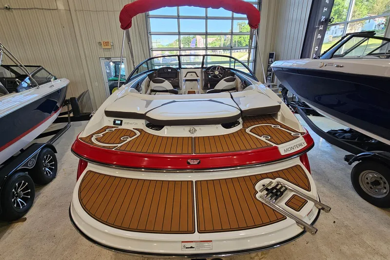 Slide: The Image of 2021 Monterey 224FS boat with teak deck, red accents, and sleek design in showroom. - 5
