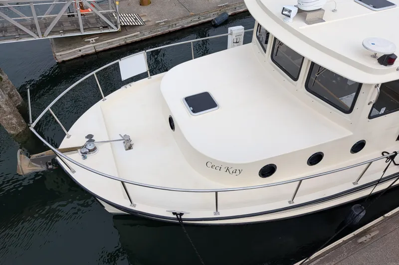 Slide: The Image of Interior of a 2001 Nordic Tug 37, featuring a cozy dining area and kitchenette. - 10