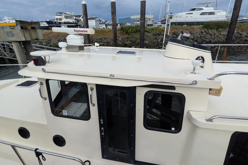 Slide: The Image of Interior of a 2001 Nordic Tug 37 with cozy seating and wooden table. - 12