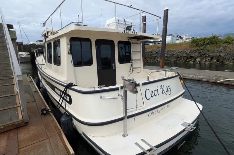 Slide: The Image of Galley kitchen in 2001 Nordic Tug 37 with stove, coffee maker, and wooden cabinetry. - 14