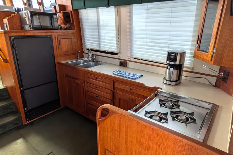 Slide: The Image of Cozy kitchen in 2001 Nordic Tug 37 boat with wooden cabinetry and modern appliances. - 18