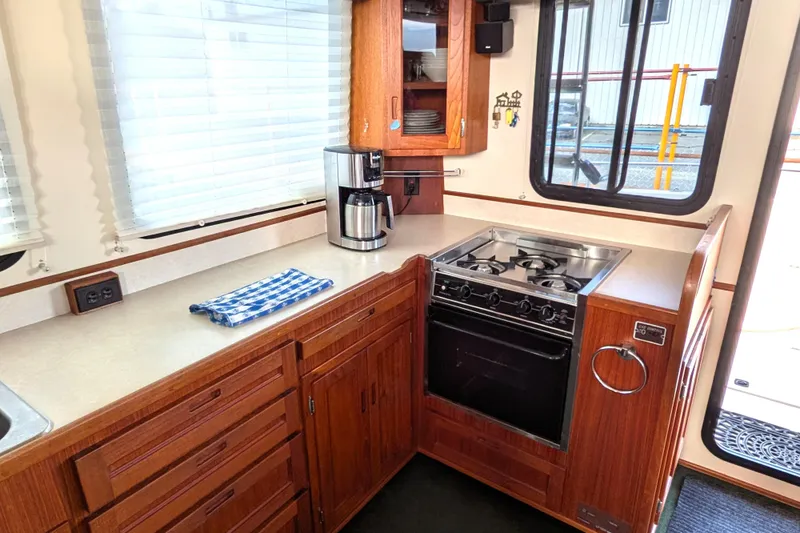 Slide: The Image of Interior of a 2001 Nordic Tug 37, featuring wooden cabinetry and navigational instruments. - 21