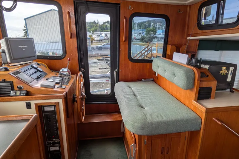 Slide: The Image of Interior of a 2001 Nordic Tug 37 with a desk, computer, and marina view. - 31