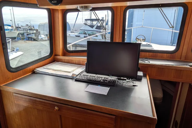 Slide: The Image of Interior of a 2001 Nordic Tug 37, featuring wooden cabinetry and nautical decor. - 38