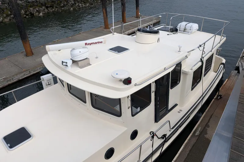 Slide: The Image of 2001 Nordic Tug 37 docked, featuring Raymarine equipment on the roof. - 4