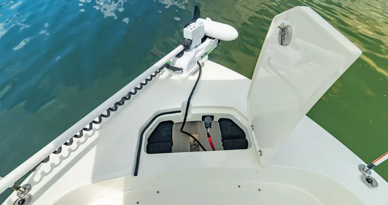 Slide: The Image of Pathfinder 2400 TRS 2027 boat with open storage compartment by the water. - 16