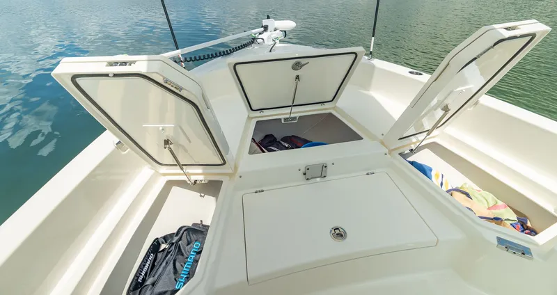 Slide: The Image of Pathfinder 2400 TRS 2027 with open storage compartments on calm water. - 14
