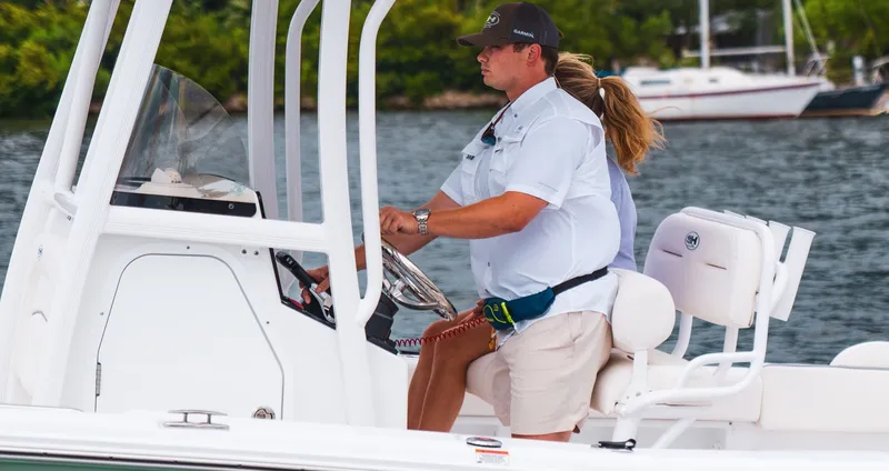 Slide: The Image of Man steering Sea Hunt Ultra 219 boat on the water. - 12