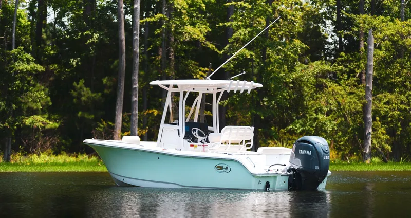 Slide: The Image of Sea Hunt Ultra 219 boat 2027 on calm water near forest. - 6