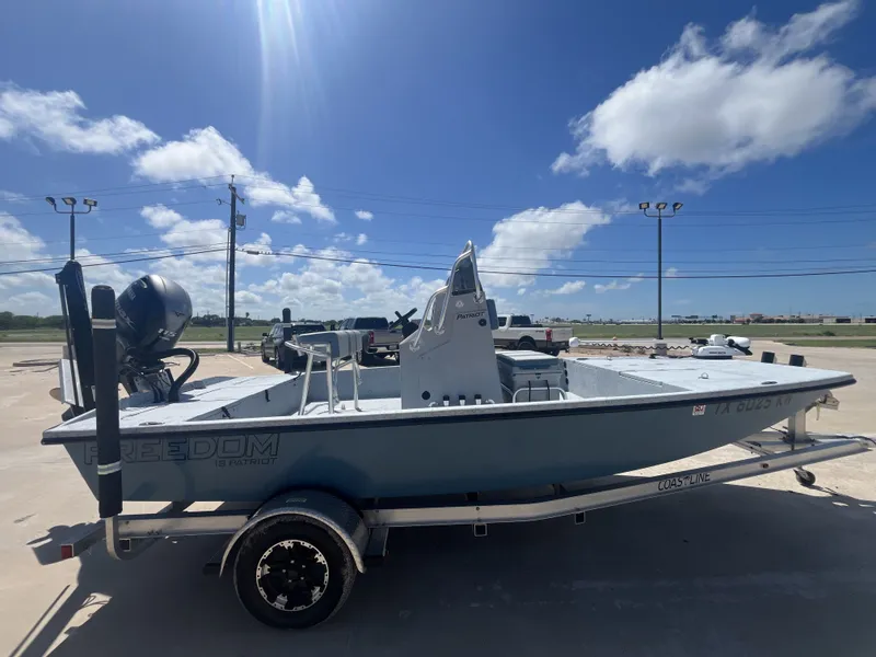 Slide: The Image of 2024 Freedom PATRIOT boat on trailer under blue sky. - 7