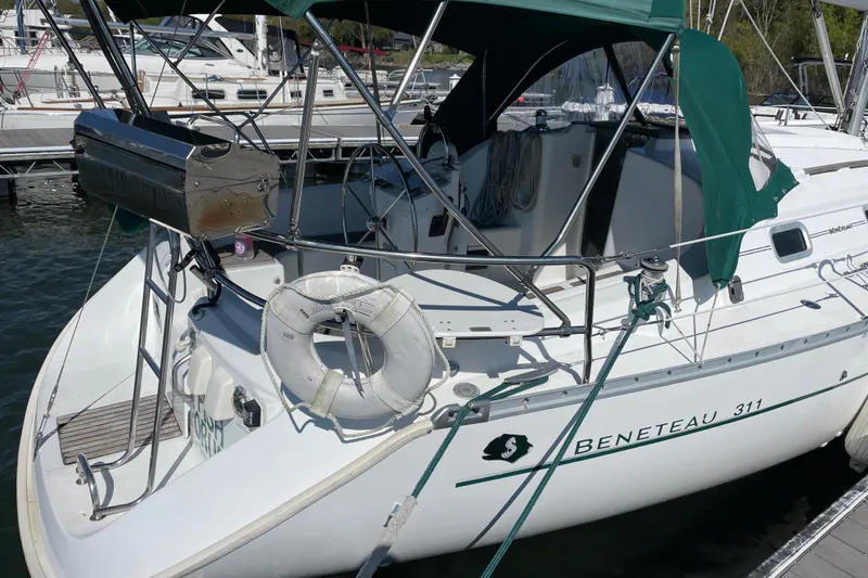 Slide: The Image of 2003 Beneteau Oceanis Clipper 311 sailboat docked, featuring green canopy and stainless steel grill. - 2