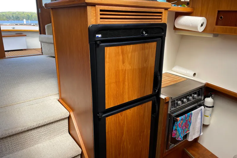 Slide: The Image of 1984 Egg Harbor 33 Convertible yacht interior with wooden cabinetry and kitchen appliances. - 10