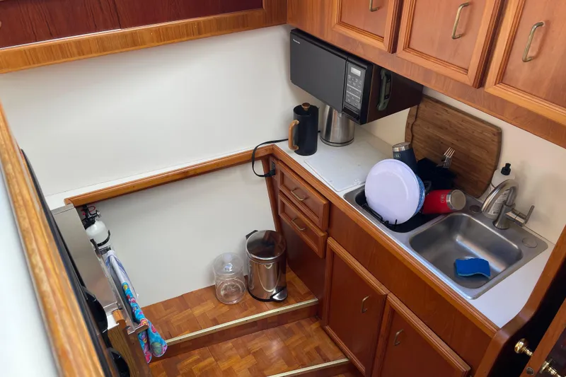 Slide: The Image of Compact kitchen area in a 1984 Egg Harbor 33 Convertible boat, featuring wooden cabinetry. - 11