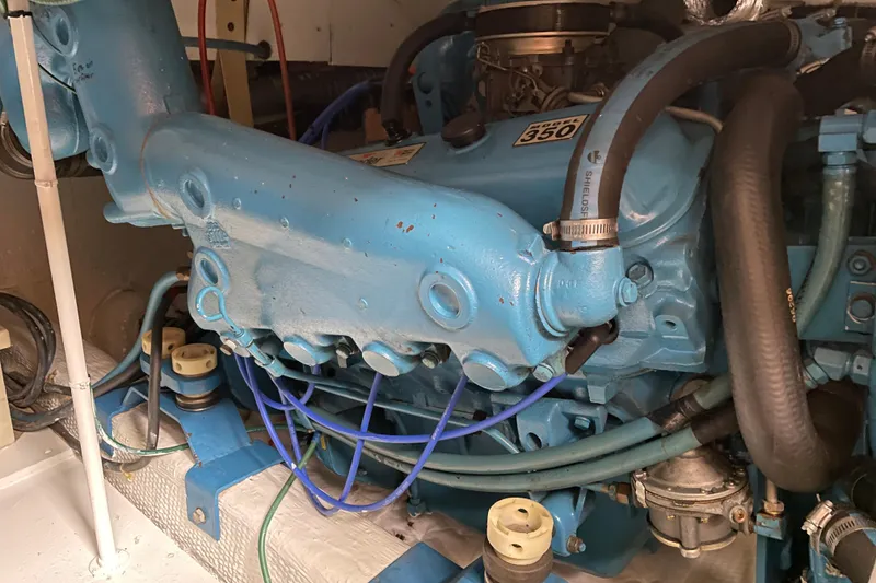 Slide: The Image of Engine of a 1984 Egg Harbor 33 Convertible boat, featuring a blue marine motor. - 12