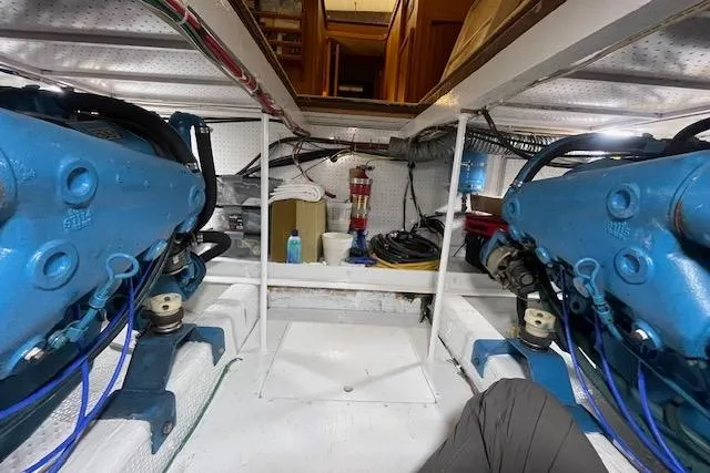 Slide: The Image of Engine room of 1984 Egg Harbor 33 Convertible boat with blue machinery and storage items. - 15