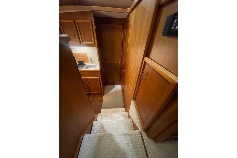 Slide: The Image of Interior of 1984 Egg Harbor 33 Convertible yacht, featuring wooden cabinetry and compact kitchen area. - 26