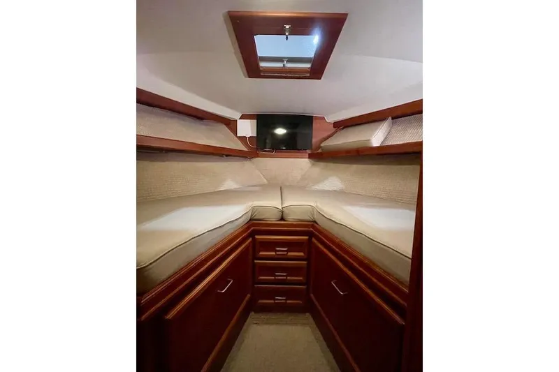 Slide: The Image of Interior cabin of 1984 Egg Harbor 33 Convertible yacht with wooden finish and cozy bedding. - 28