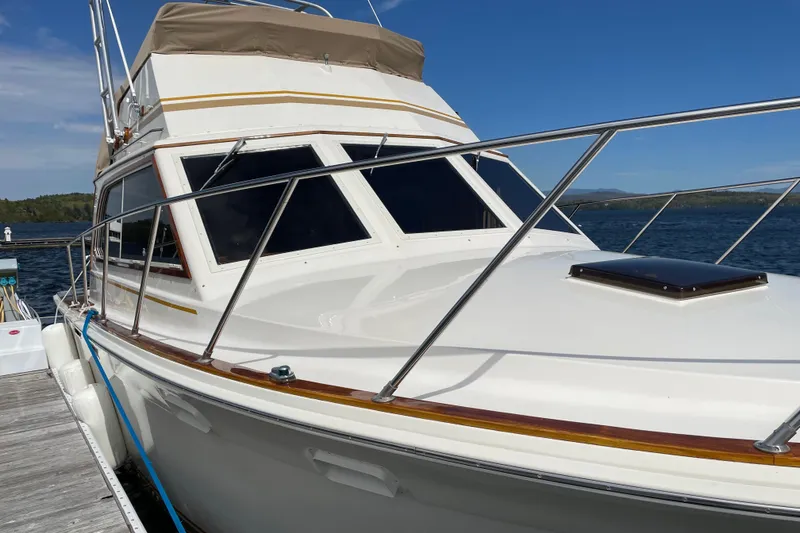 Slide: The Image of 1984 Egg Harbor 33 Convertible yacht docked by the water on a sunny day. - 3