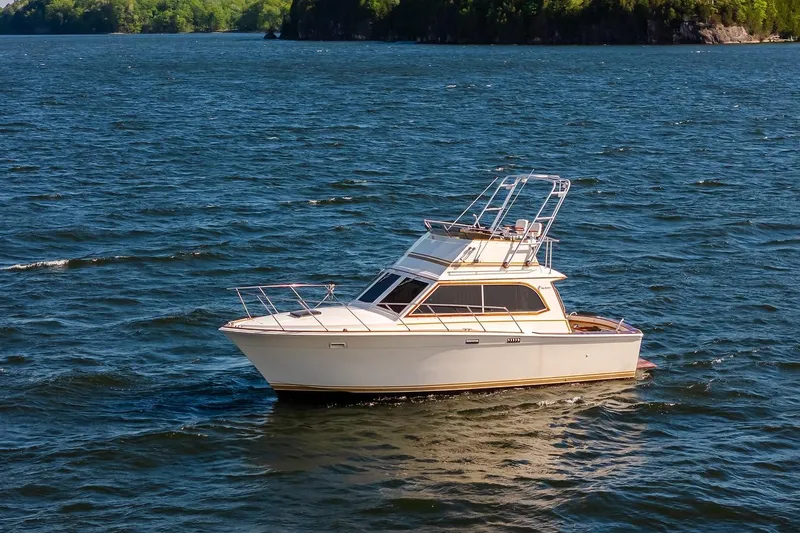 Slide: The Image of 1984 Egg Harbor 33 Convertible yacht docked at sunset, serene waterfront view. - 38