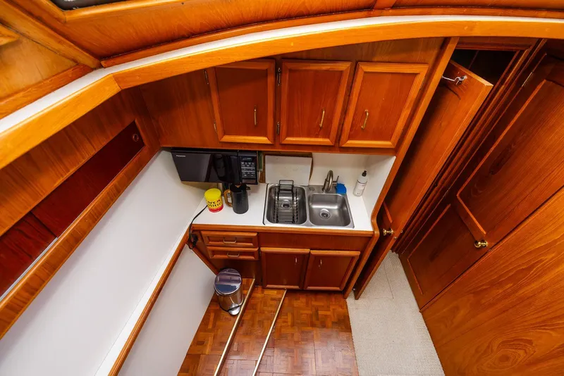 Slide: The Image of 1984 Egg Harbor 33 Convertible yacht kitchen with wooden cabinets and stainless steel sink. - 45