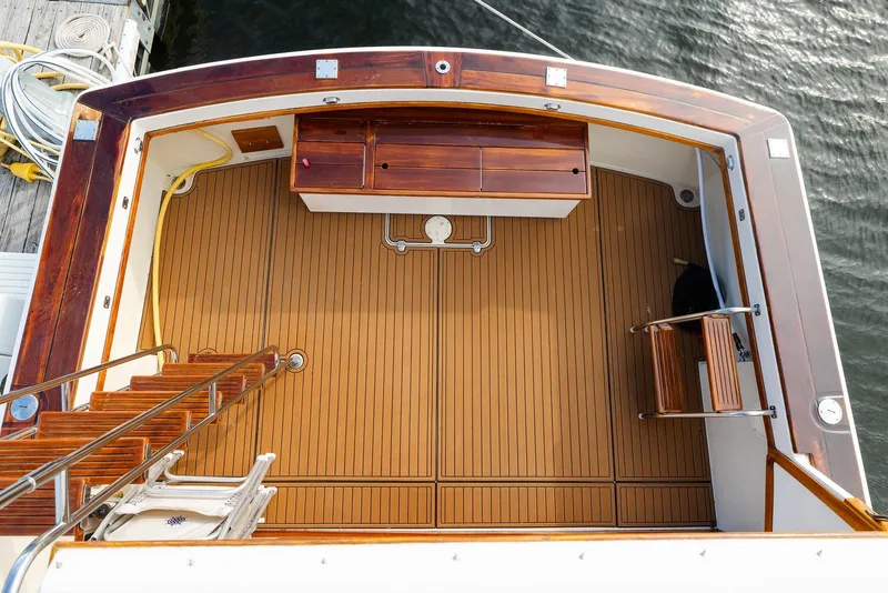 Slide: The Image of 1984 Egg Harbor 33 Convertible boat deck with wooden flooring and storage compartments. - 52