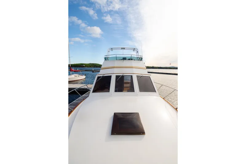 Slide: The Image of 1984 Egg Harbor 33 Convertible yacht docked, showcasing sleek design and spacious deck. - 54