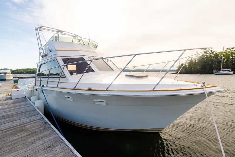 Slide: The Image of 1984 Egg Harbor 33 Convertible yacht docked on a serene lake. - 56