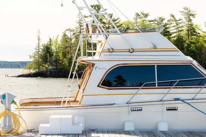 Slide: The Image of 1984 Egg Harbor 33 Convertible yacht docked by a scenic lakeside. - 57