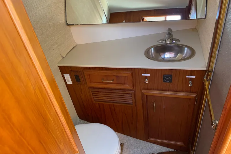 Slide: The Image of 1984 Egg Harbor 33 Convertible yacht bathroom with wooden cabinetry and stainless steel sink. - 9