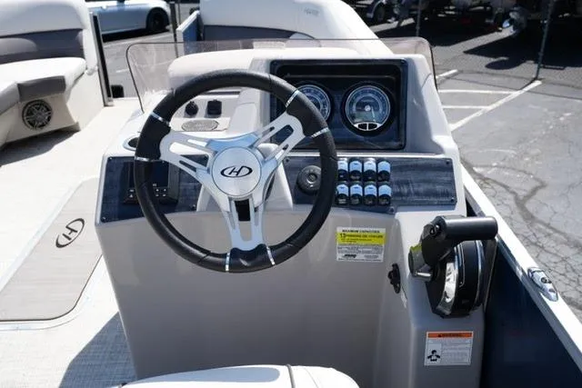 Slide: The Image of 2023 Harris Cruiser 230 CW boat dashboard with steering wheel and control panel. - 11