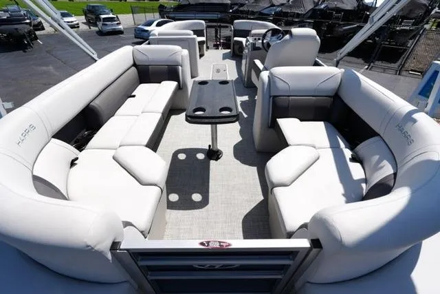 Slide: The Image of 2023 Harris Cruiser 230 CW pontoon boat interior with plush seating and central table. - 13