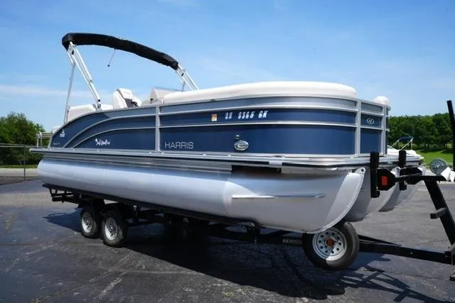 Slide: The Image of 2023 Harris Cruiser 230 CW pontoon boat on trailer, parked outdoors. - 3