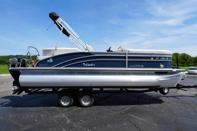 Slide: The Image of 2023 Harris Cruiser 230 CW pontoon boat on trailer, parked outdoors under clear sky. - 4