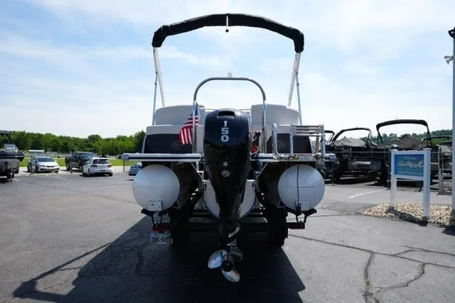 Slide: The Image of 2023 Harris Cruiser 230 CW pontoon boat with outboard motor, parked outdoors. - 6