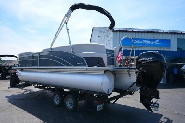 Slide: The Image of 2023 Harris Cruiser 230 CW pontoon boat on trailer, parked outside dealership. - 7