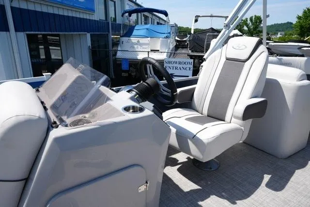 Slide: The Image of 2023 Harris Cruiser 230 CW boat interior with captain's chair and steering console. - 9