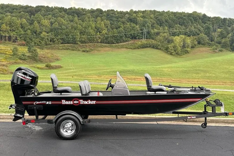The Image of 2026 Tracker Bass Tracker Classic XL boat on trailer, set against a scenic green landscape. - 0