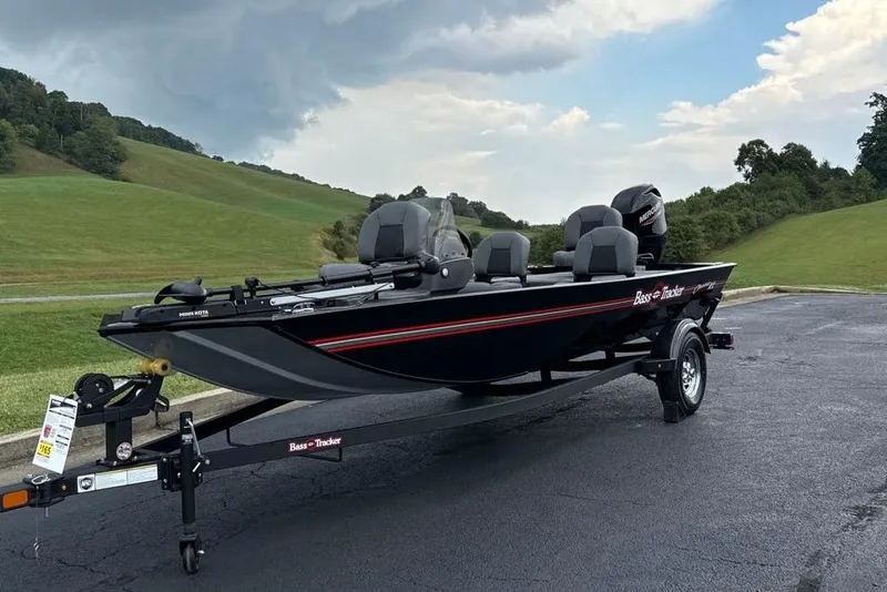 Slide: The Image of 2026 Tracker Bass Tracker Classic XL boat on trailer, parked on asphalt near grassy hills. - 3
