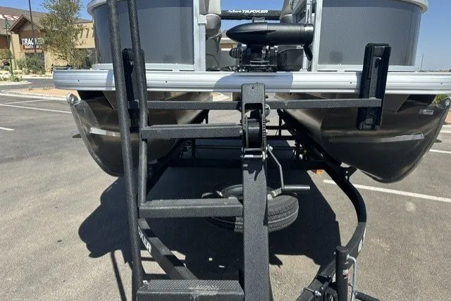 Slide: The Image of 2026 Sun Tracker Bass Buggy 16 XL Select pontoon boat on trailer in parking lot. - 22
