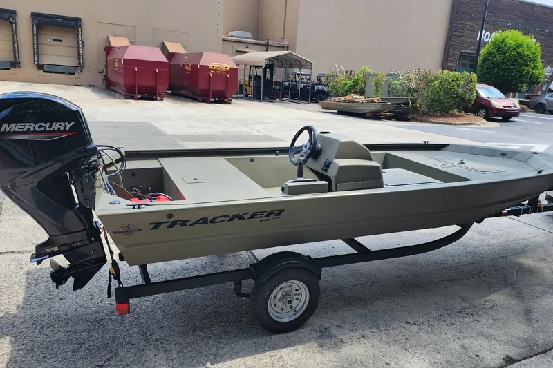 Slide: The Image of 2026 Tracker Grizzly 1648 SC boat with Mercury engine on trailer in parking lot. - 2