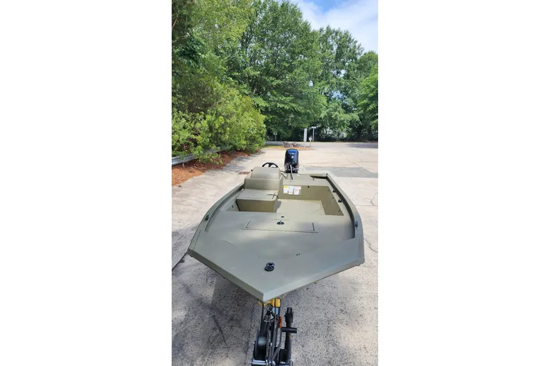 Slide: The Image of 2026 Tracker Grizzly 1648 SC boat on trailer, surrounded by greenery. - 3