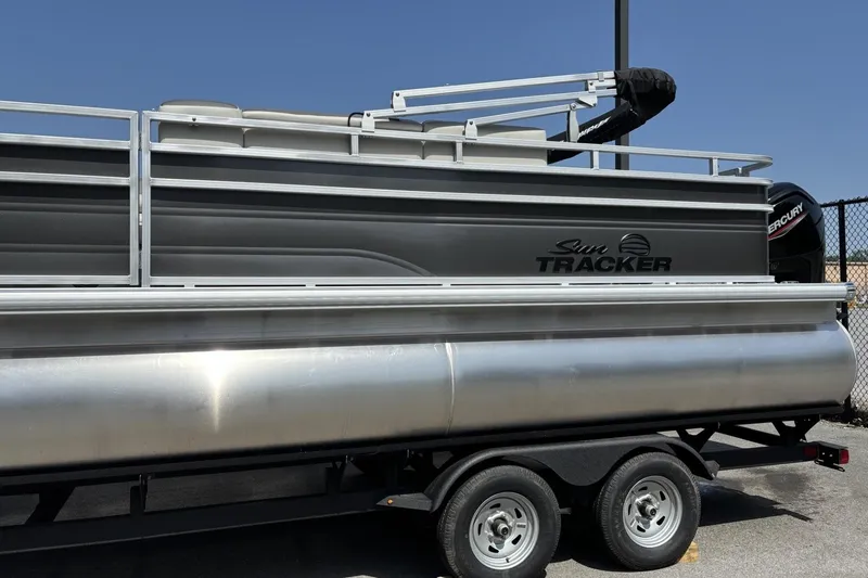 Slide: The Image of 2026 Sun Tracker Fishin' Barge 20 DLX pontoon boat on trailer, side view. - 1