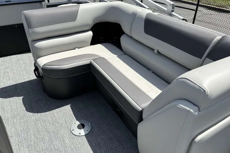 Slide: The Image of 2026 Sun Tracker Fishin' Barge 20 DLX interior seating with gray upholstery and carpeted flooring. - 5