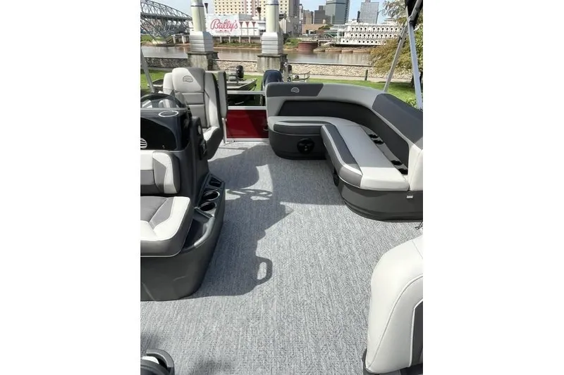 Slide: The Image of 2026 Sun Tracker Bass Buggy 16 XL Select pontoon boat interior with seating and cityscape background. - 6