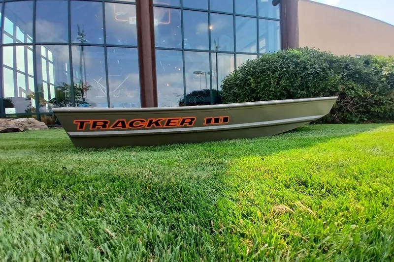 The Image of 2026 Tracker Grizzly 10 Jon boat displayed on grass outside a modern building. - 0