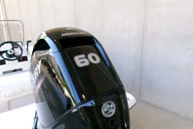 Slide: The Image of 2026 Mako Pro Skiff 15 CC with Mercury 60 outboard motor, steering wheel visible. - 5