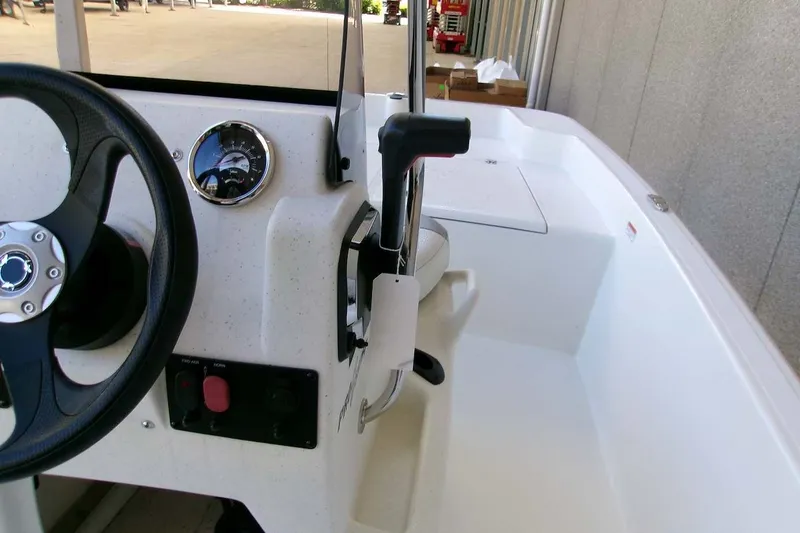 Slide: The Image of 2026 Mako Pro Skiff 15 CC boat interior with steering wheel and control panel. - 14