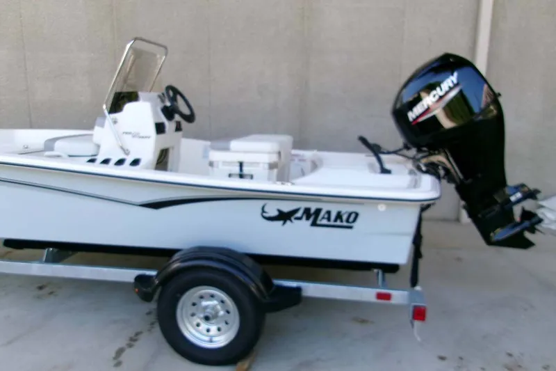 Slide: The Image of 2026 Mako Pro Skiff 15 CC boat with Mercury outboard motor on trailer. - 2