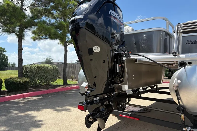 Slide: The Image of 2026 Sun Tracker Bass Buggy 18 DLX with Mercury outboard motor in a sunny outdoor setting. - 7