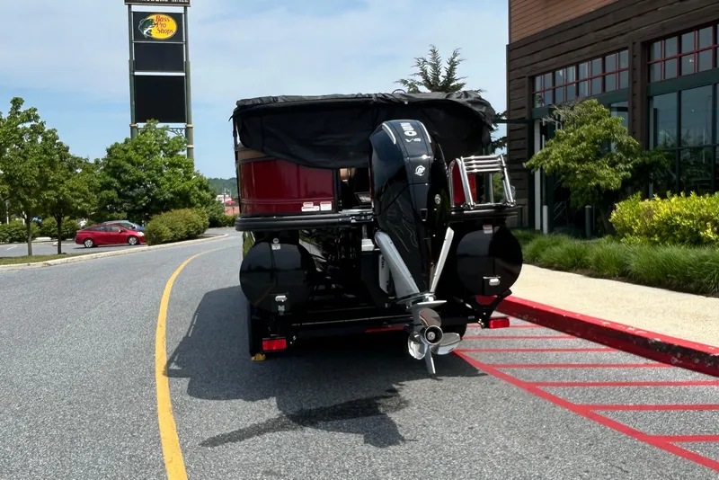 Slide: The Image of 2026 Regency 250 DL boat with outboard motor parked near Bass Pro Shops. - 2